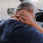 Driver holding his neck after a car accident
