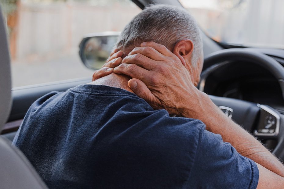 Driver holding his neck after a car accident
