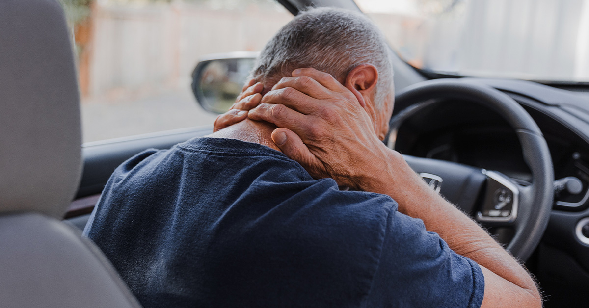 Driver holding his neck after a car accident