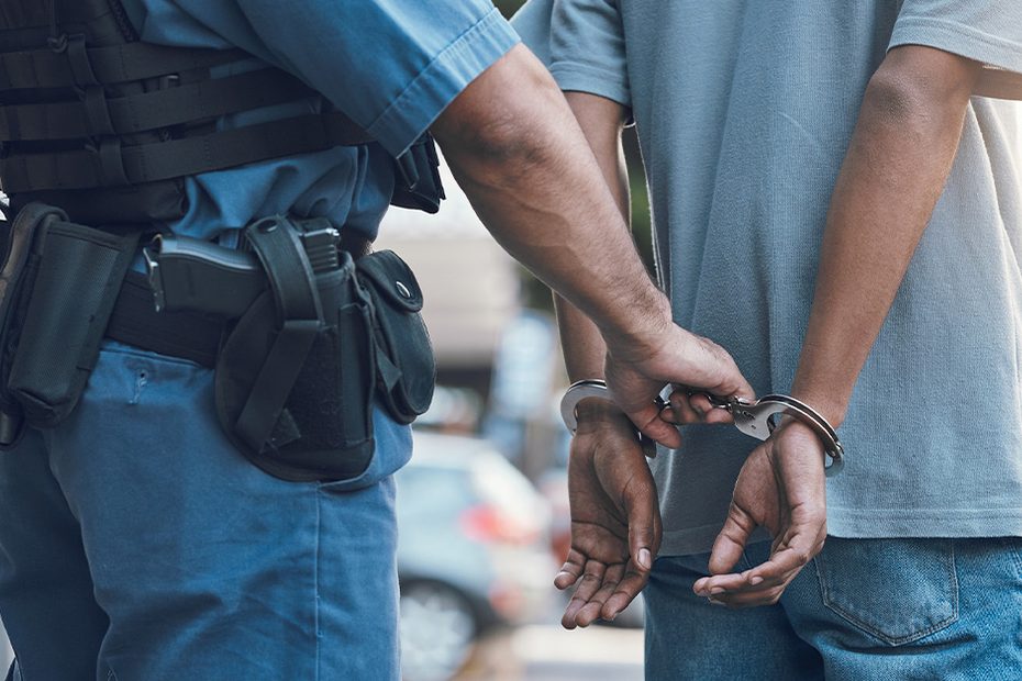Police officer holding a handcuffed person